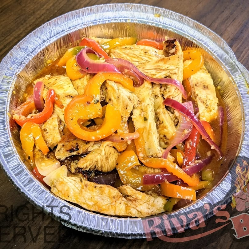Riva's BBQ chicken fajitas with colorful bell peppers and red onions in a foil take-out container.