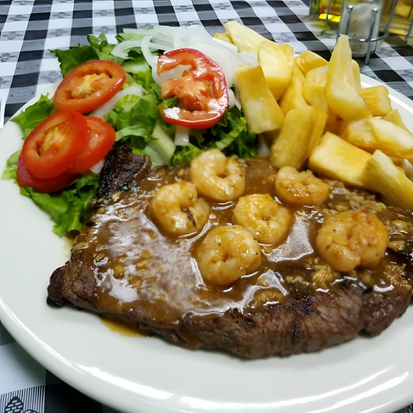 Riva's Bbq Restaurant's steak with shrimp, salad, and fries on a white plate.